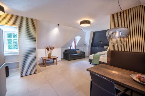 a living room with a bed and a dining room at Schloss Hantberg Apartments 