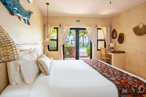 a bedroom with a large white bed in a room at Kalimera Beach Hotel in Maya Beach