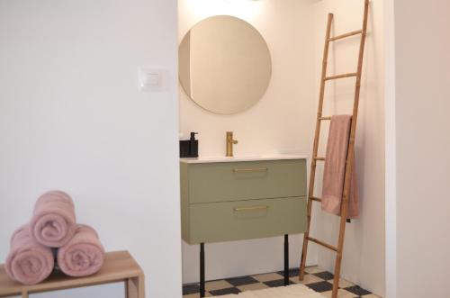 bagno con cassettiera verde e specchio di Maison - Halle 16 Heritage ad Agde