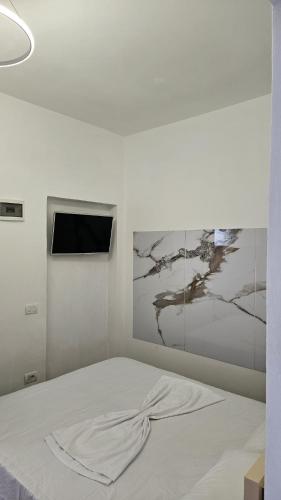 una camera da letto con un letto bianco e un quadro sulla parete di Neta apartments a Velipojë