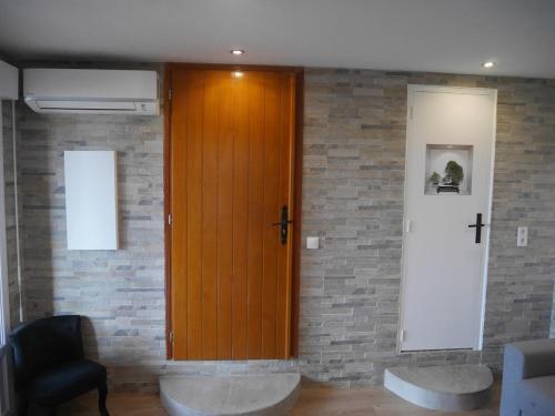 - une porte en bois dans une chambre dotée d'un mur en briques dans l'établissement Pleasant air-conditioned T2 apartment in Ile Rousse, à LʼÎle-Rousse