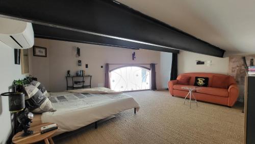 une chambre avec un grand lit et un canapé dans l'établissement Maison au cœur d'un village, vue sur les montagnes, à Bélesta