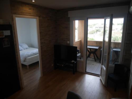 un salon avec un lit et une télévision dans l'établissement Pleasant air-conditioned T2 apartment in Ile Rousse, à LʼÎle-Rousse