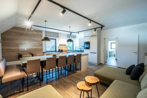 a kitchen and living room with a long table and chairs at Schloss Hantberg Apartments 