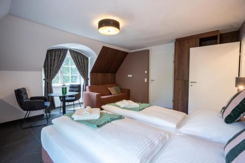 a hotel room with two beds and a table at Schloss Hantberg Apartments 