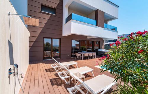 patio z białymi krzesłami i stołami na domu w obiekcie Villa Estate w Novalji