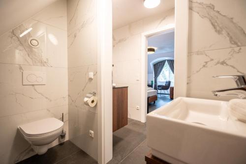 a bathroom with a toilet and a sink and a tub at Schloss Hantberg Apartments 