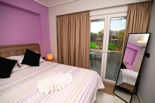 a bedroom with a bed with purple walls and a mirror at Diamond Serenity Villa in Kardamaina