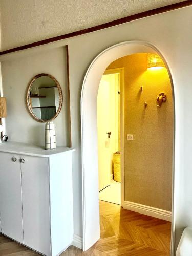 une arche dans une pièce avec un miroir et un couloir dans l'établissement Pramousquier -Vue mer - 3 pièces - rénové à neuf, au Lavandou