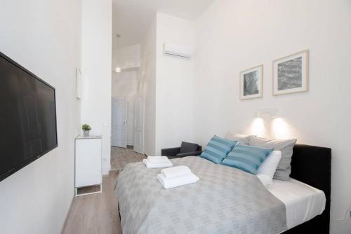 a bedroom with a bed and a flat screen tv at Modern studio with AirCon and balcony in the center in Budapest