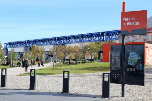 a sign in a park with a bridge in the background at Hotel Paris Villette in Paris