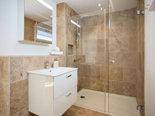 a bathroom with a shower and a sink and a mirror at Appartement Carla in Westerland (Sylt)