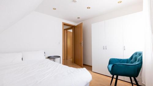 a bedroom with a bed and a blue chair at Simplex Stays Heilbronn Louis-Hentges-Str in Heilbronn