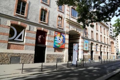 a building with signs on the side of a street at Hotel Paris Villette in Paris