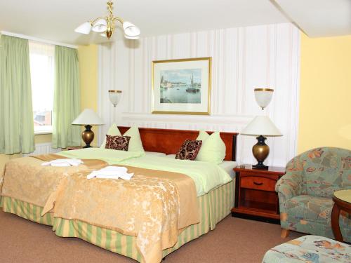 シェーナウ・イム・シュヴァルツヴァルトにあるParkhotel Sonneのベッドと椅子付きのホテルルーム
