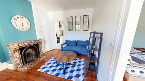un salon avec un canapé bleu et une cheminée dans l'établissement Bougainville - T2 Comfort & Quiet & Train Station, au Havre