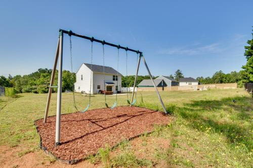 a swing in a field with a house in the background at Modern Anderson Home with Fire Pit and Grill in Anderson