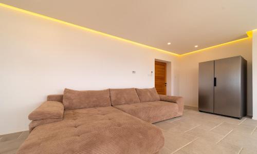 a living room with a brown couch and a refrigerator at Villa Mianka Rab in Banjol