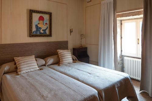 a bedroom with a bed with a picture on the wall at Guest house SAL E PEDRA in Villanueva de Arosa