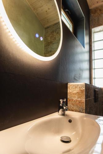 a bathroom with a sink and a round mirror at Villa Mianka Rab in Banjol