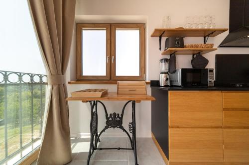 a kitchen with a counter and a table and a window at Villa Mianka Rab in Banjol