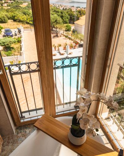 a vase of flowers sitting on a window sill at Villa Mianka Rab in Banjol