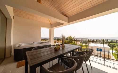 a dining room with a table and chairs on a balcony at Villa Mianka Rab in Banjol