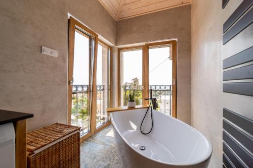 a bath tub in a bathroom with windows at Villa Mianka Rab in Banjol