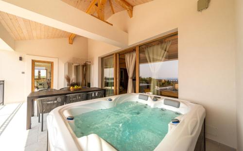 a jacuzzi tub in a room with a large window at Villa Mianka Rab in Banjol