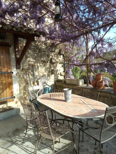 une table et des chaises en bois sur une terrasse dans l'établissement La maison Chabert, à Ailhon