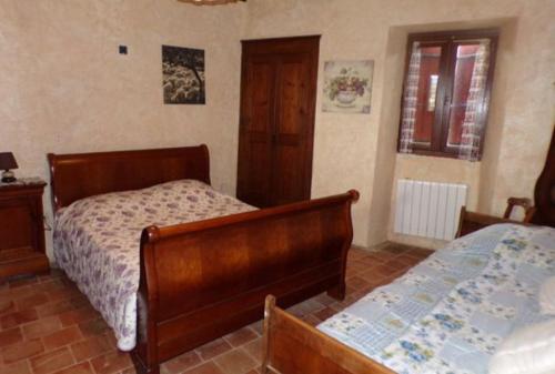 une chambre avec deux lits et une fenêtre dans l'établissement La maison Chabert, à Ailhon