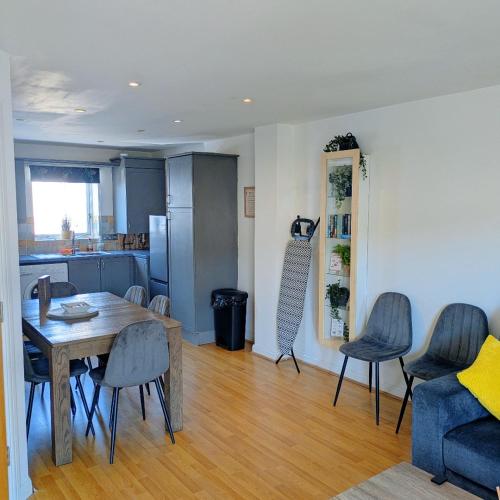 a living room with a table and chairs and a kitchen at The Dover House with river and Castle views in Dover