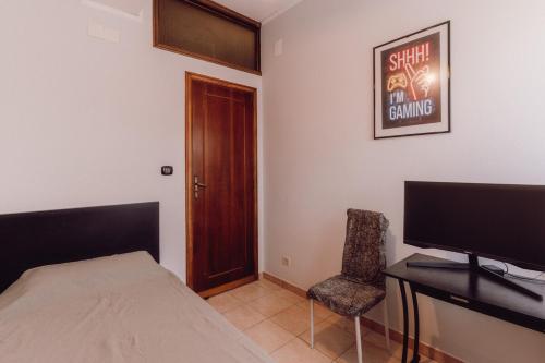 a bedroom with a bed and a desk and a television at Locri Beautiful Modern Three-Room Apartment in Locri