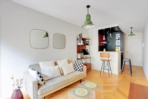 un salon avec un canapé et une table dans l'établissement Appartement spacieux avec terrasse proche hôpital américain, à Levallois-Perret