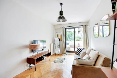un salon avec un canapé et une table dans l'établissement Appartement spacieux avec terrasse proche hôpital américain, à Levallois-Perret