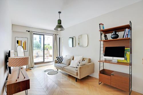 un salon avec un canapé et une télévision dans l'établissement Appartement spacieux avec terrasse proche hôpital américain, à Levallois-Perret