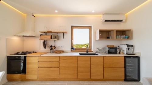 a kitchen with wooden cabinets and a window at Villa Mianka Rab in Banjol