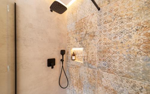 a bathroom with a shower with a phone on the wall at Villa Mianka Rab in Banjol