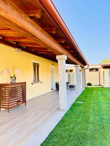 a patio with awning and a green lawn at CASA SACURI in Rudalza