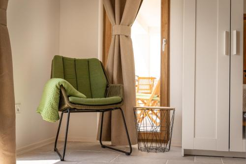 a green chair in a room with a window at Villa Mianka Rab in Banjol