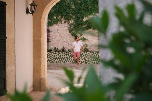 a woman standing in an archway of a building at Es Figueral Nou Hotel Rural & Spa - Adults Only - Over 12 in Montuiri