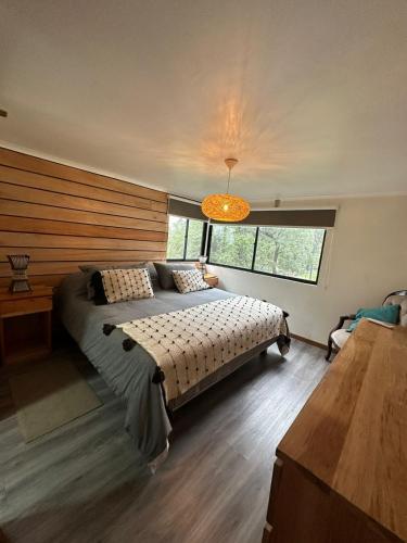 a bedroom with a bed and a large window at Leñador in Antuco