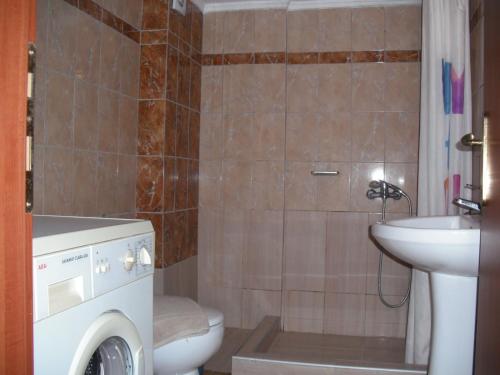 a bathroom with a washing machine and a sink at Top Apartment in Keramotí