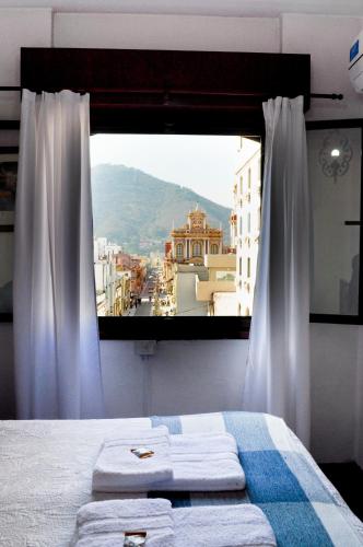a bedroom with a window with a view of a city at Hotel Regidor in Salta