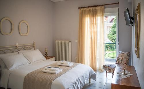 a bedroom with a bed and a chair and a window at 4keys House 4 in Tripolis