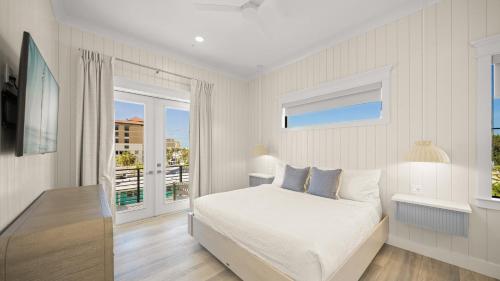 a white bedroom with a bed and a window at Salty Sunrise in Clearwater Beach