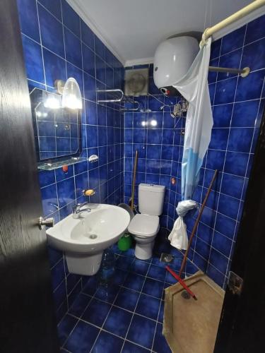 a blue tiled bathroom with a toilet and a sink at Porto Matrouh Chalet شاليه بورتو مطروح in Marsa Matruh