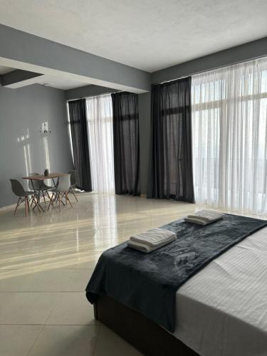 a bedroom with a bed and a table with chairs at Freske Rooms in Krujë