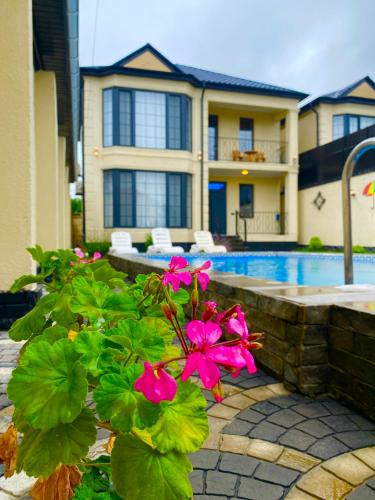 a house with a swimming pool and pink flowers at Gabala Double Villas in Gabala