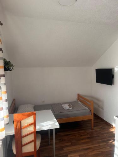 een kleine kamer met een tafel, een bed en een bureau bij Apartmani Kaić in Livno